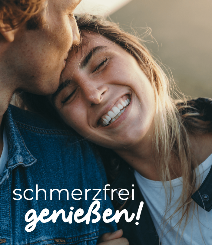 Eine lächelnde blonde Frau mit geschlossenen Augen lehnt sich an die Schulter eines Mannes, der ihre Stirn küsst. Der Mann trägt eine Jeansjacke. Auf dem Bild steht "schmerzfrei genießen!".