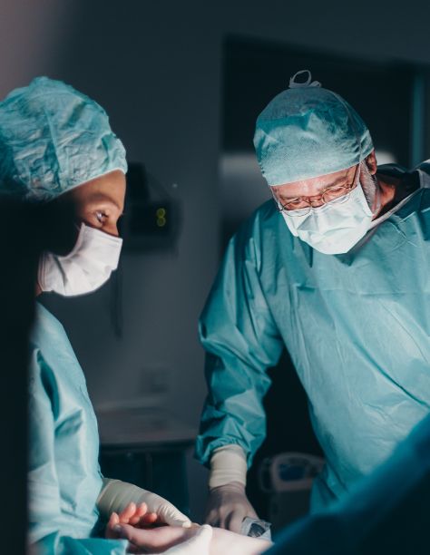 Chirurgen in OP-Kleidung konzentrieren sich auf eine medizinische Prozedur im Operationssaal.